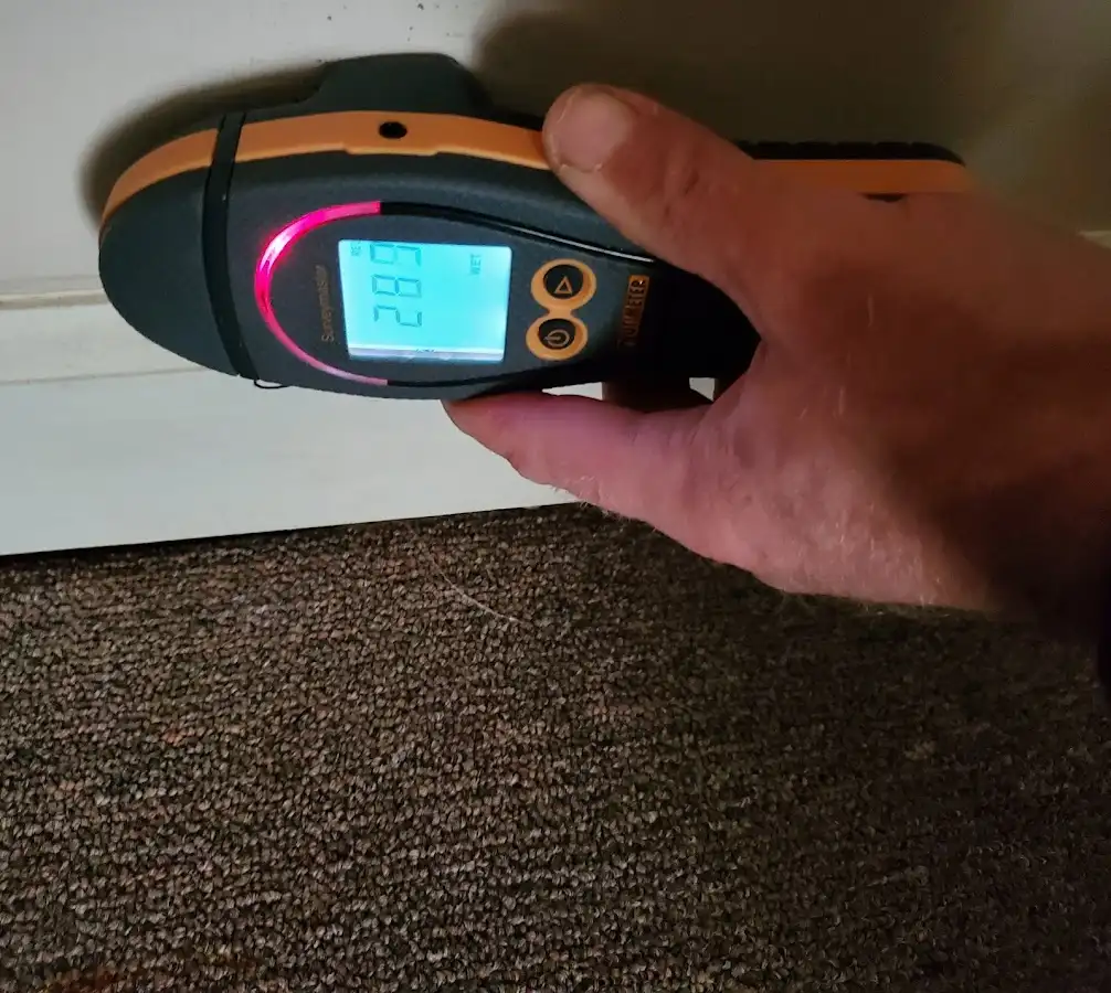 Moisture detection at baseboard during Storm Damage Restoration in De Witt